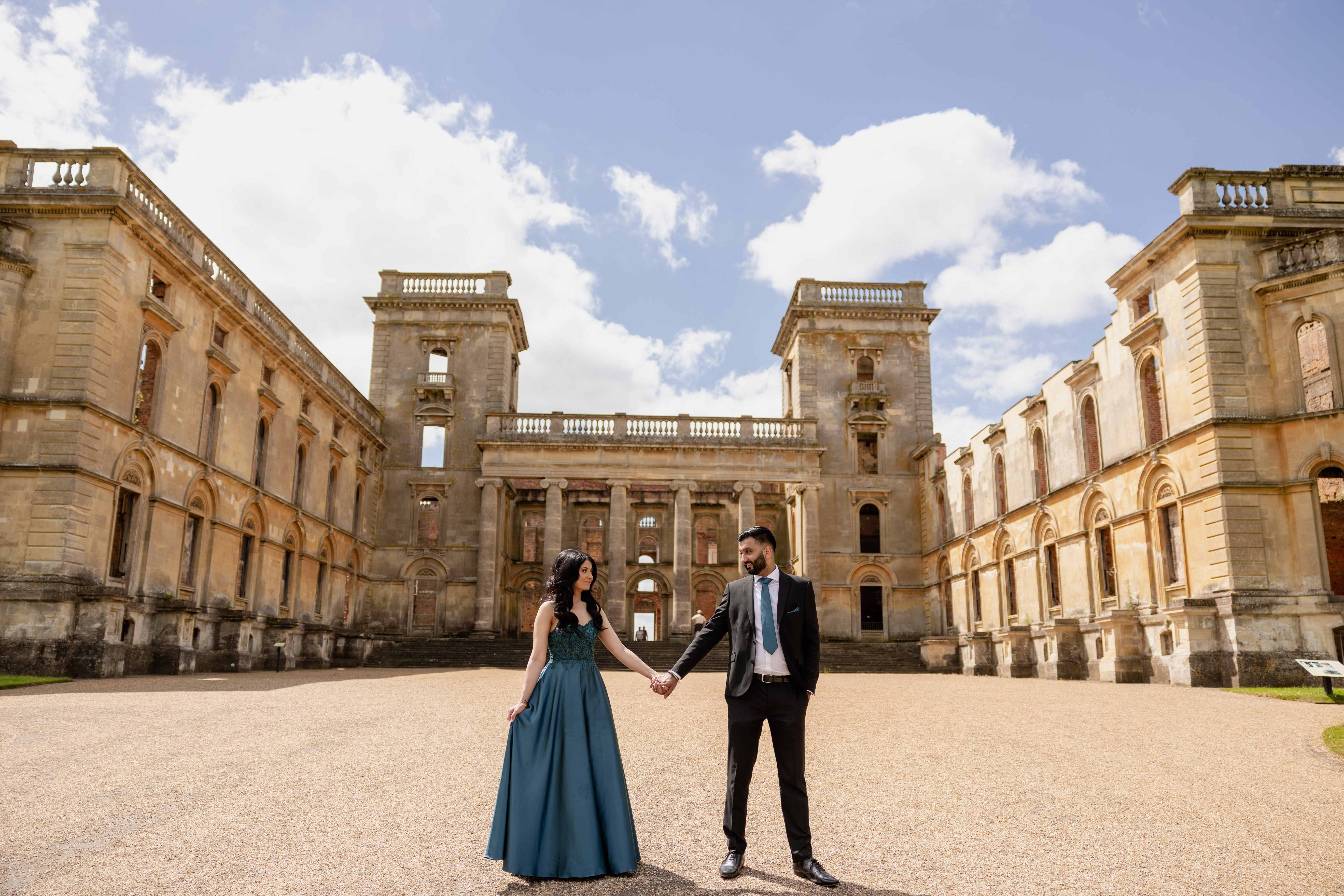 Couple holding hands at historic manor courtyard