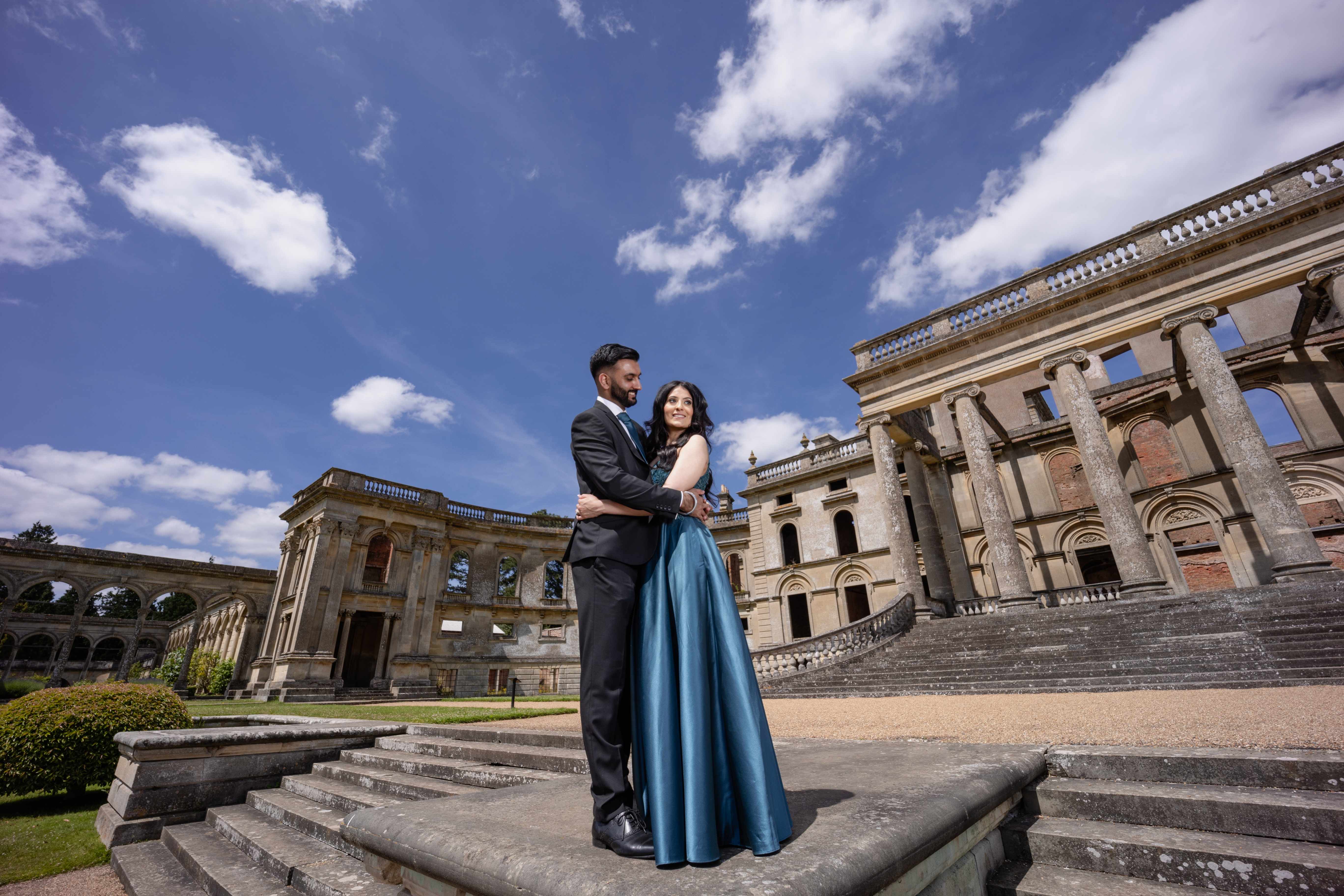 Romantic couple embracing at grand palace with blue sky